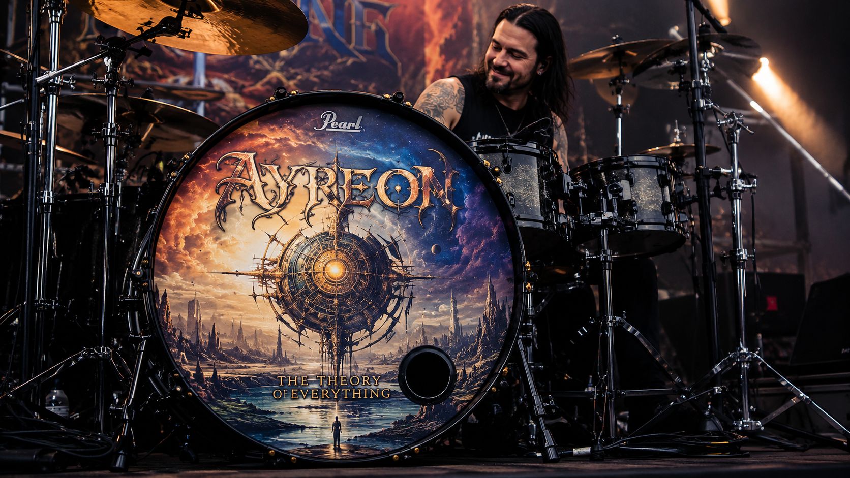 A professional drummer sitting behind a large bass drum with an Ayreon logo and artwork on it.